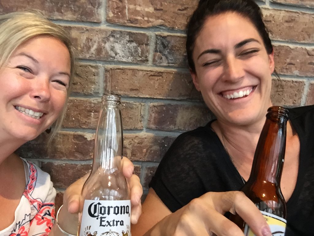 Photo of 2 girls drinking a beer together.