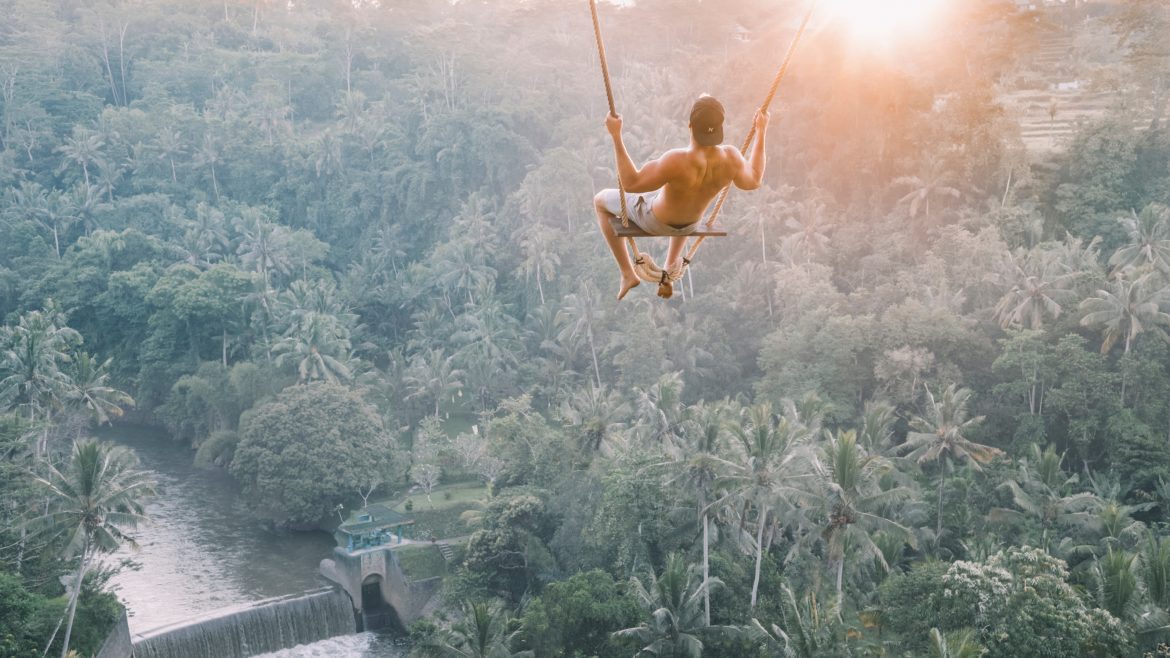 Photo of a dude swinging in the trees