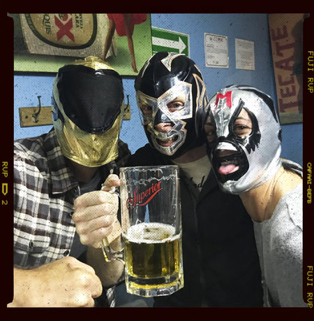 People drinking beer and wearing luchador masks