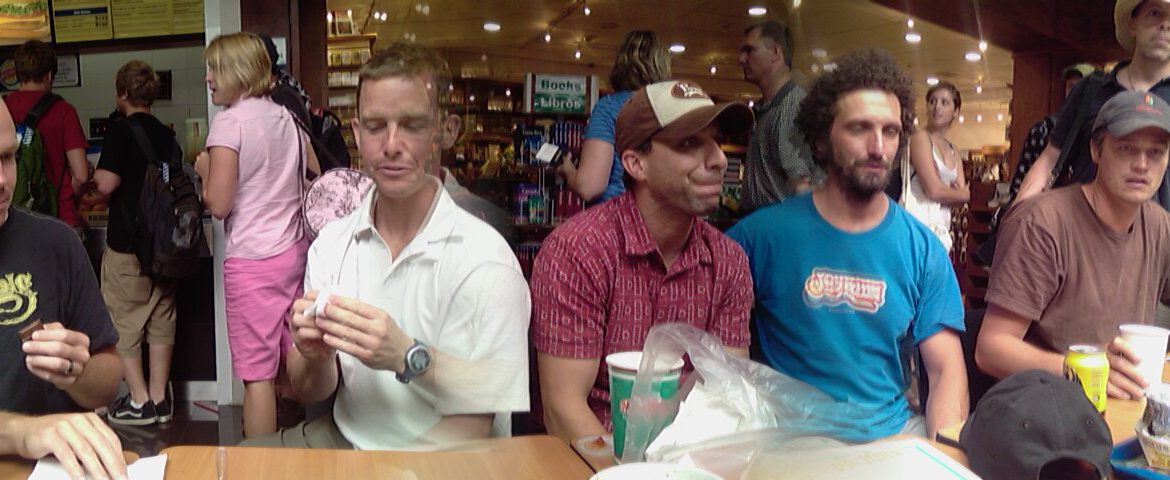 Photo of some guys eating while waiting for their flight