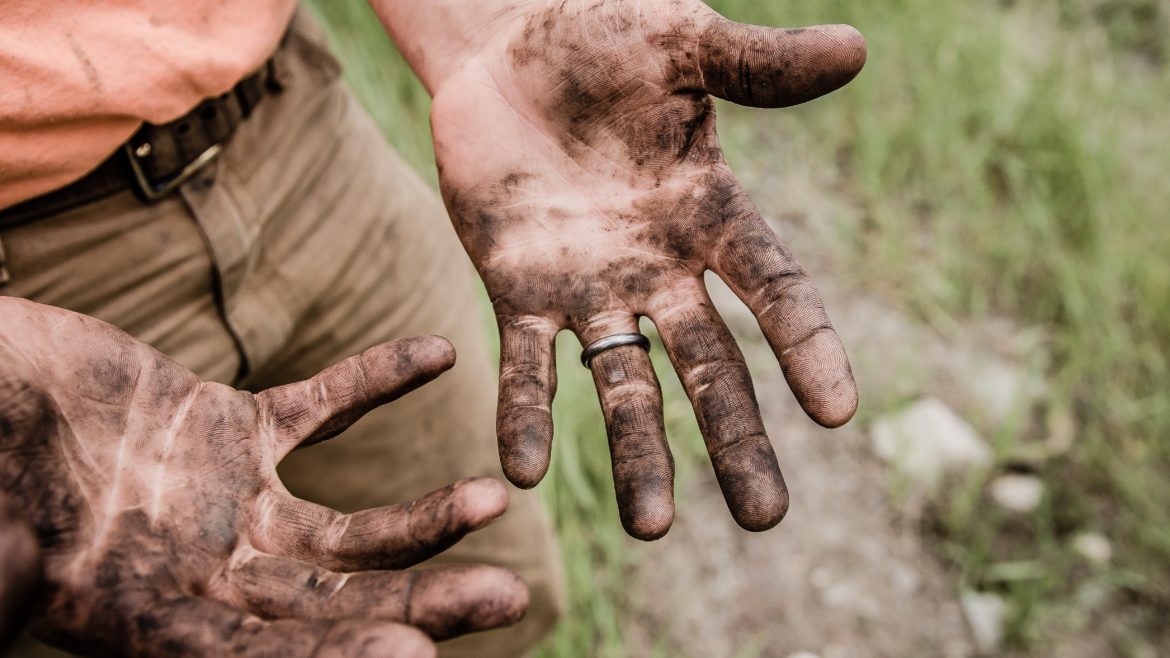 Photo of a dude with muddy hands